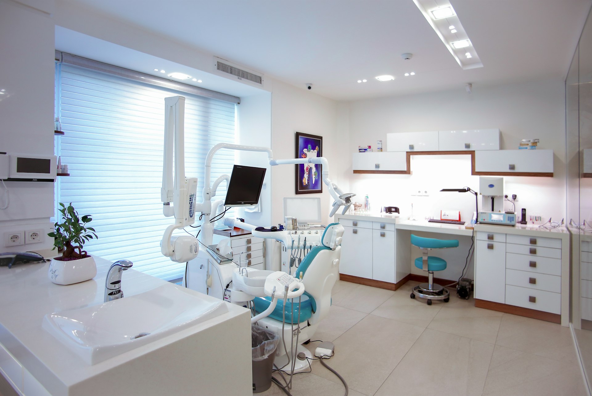 Gabinete dental con sillón, lámpara y ventanales con luz natural.